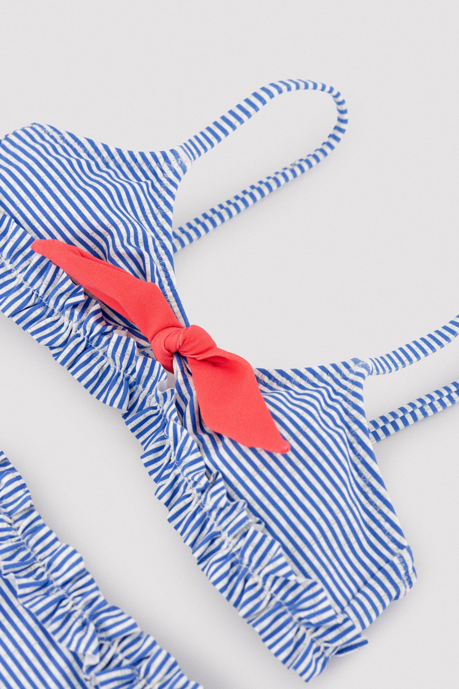 Bikini da bambina con fiocco e arricciatura, stampa a righe