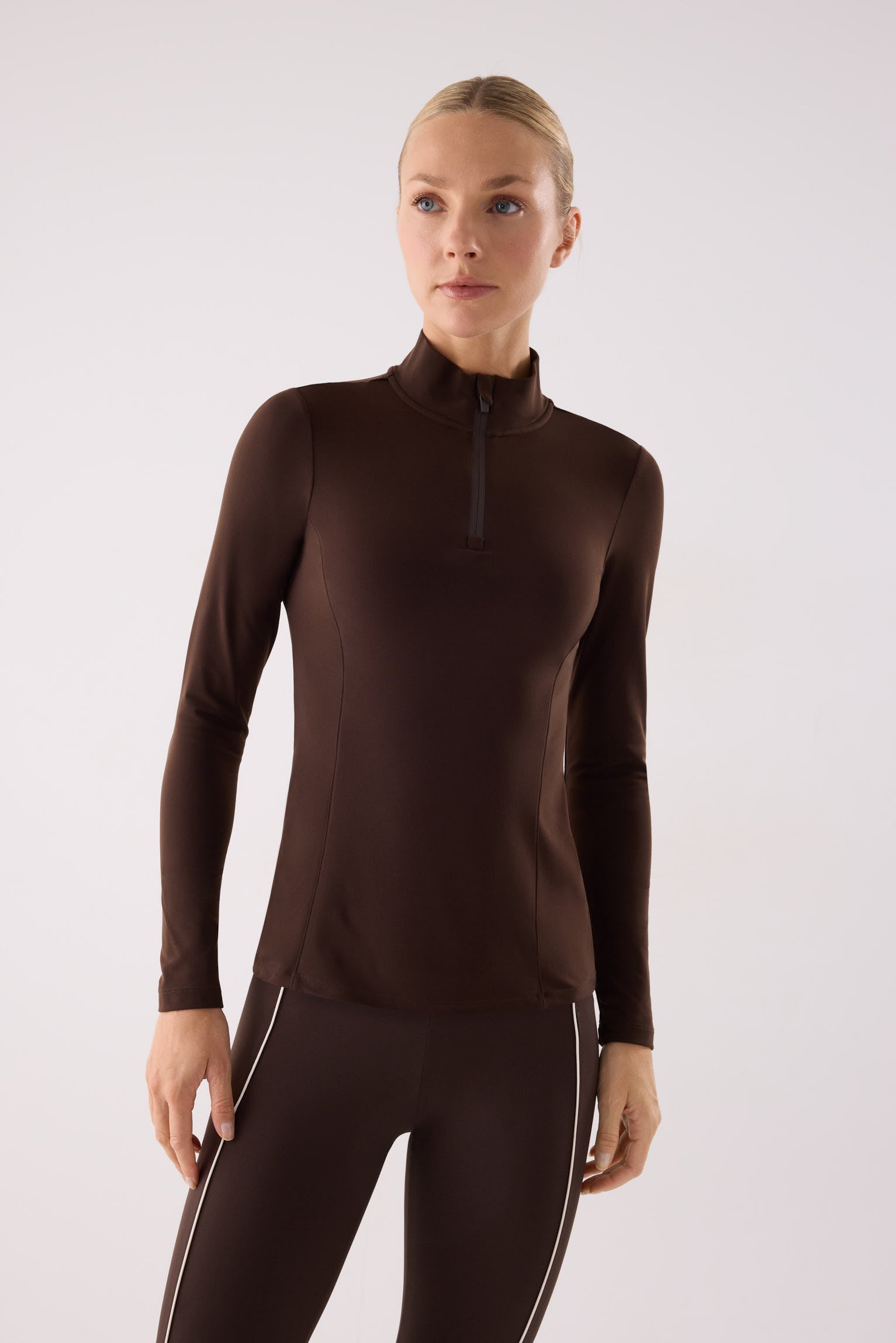 camiseta deportiva manga larga con media cremallera gimnasio en marrón dark chocolate vista principal en look deportivo tejido transpirable con interior afelpado